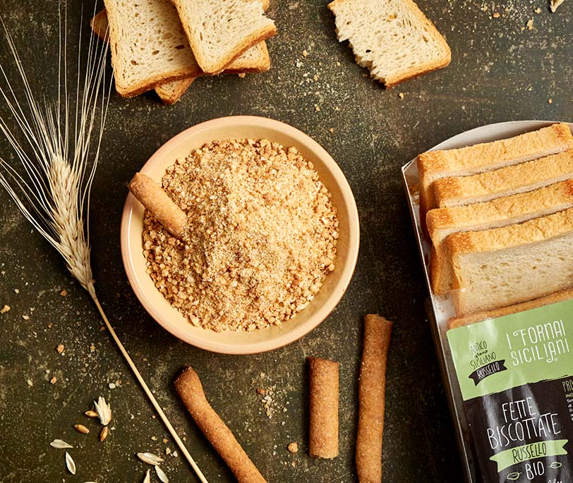 Il pane grattugiato in una ciotola di legno. Le pangrattato secche, note  come panatura o croccante, sono tagliate a fette ​​residue di pane secco,  utilizzato per la panatura o la sbriciolazione Foto